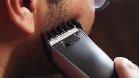 man trimming his beard with an electric trimmer