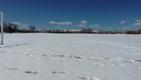 Eine-Laufende-Drohne-Schoss-Nach-Einem-Frühlingsschnee-über-Ein-Leeres-Fußballfeld