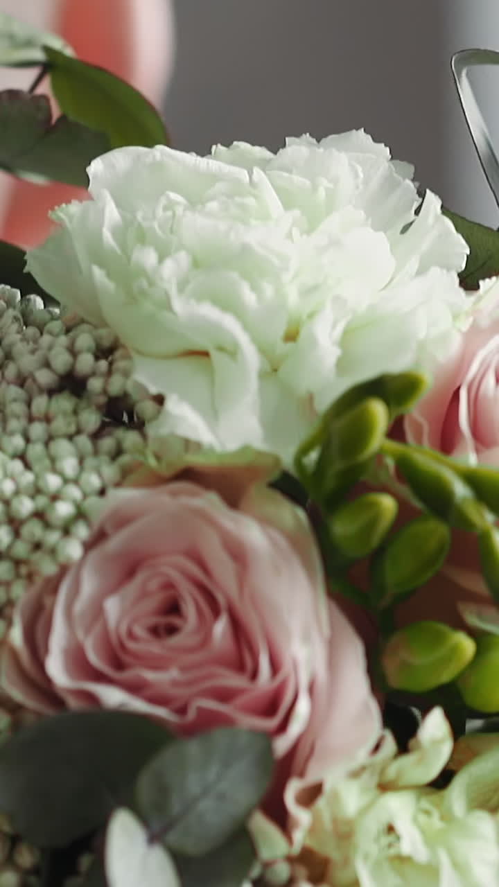 Groom puts elegant wedding bouquet on shoulder in studio close back view slow motion. Ready for festive wedding ceremony. Floral decor for holiday event