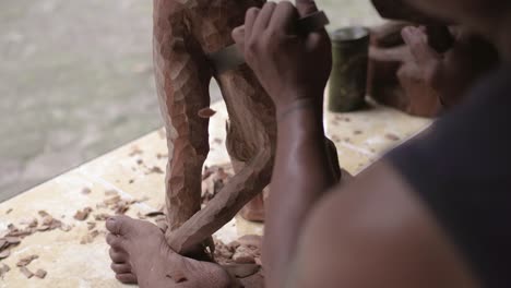 hombre haciendo una estatua de madera