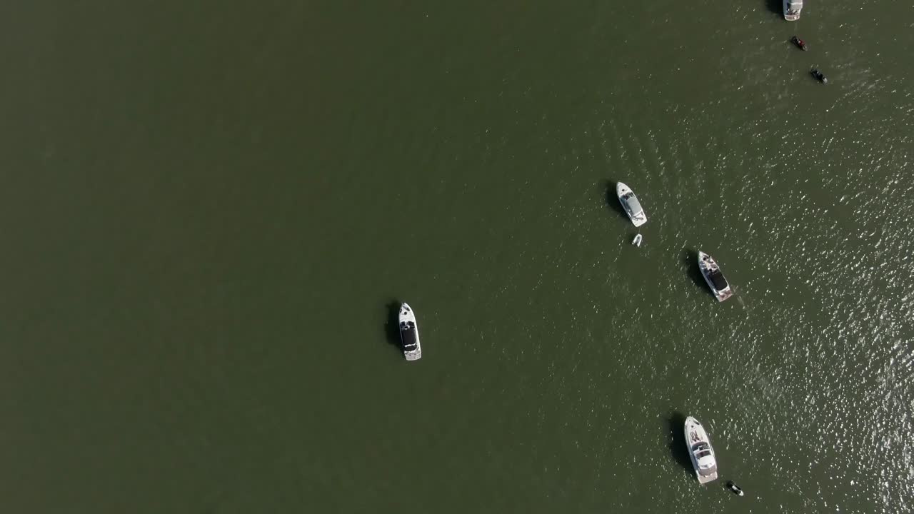 Piccoli yacht nell'acqua, ripresa aerea verticale dall'alto, traccia a destra.