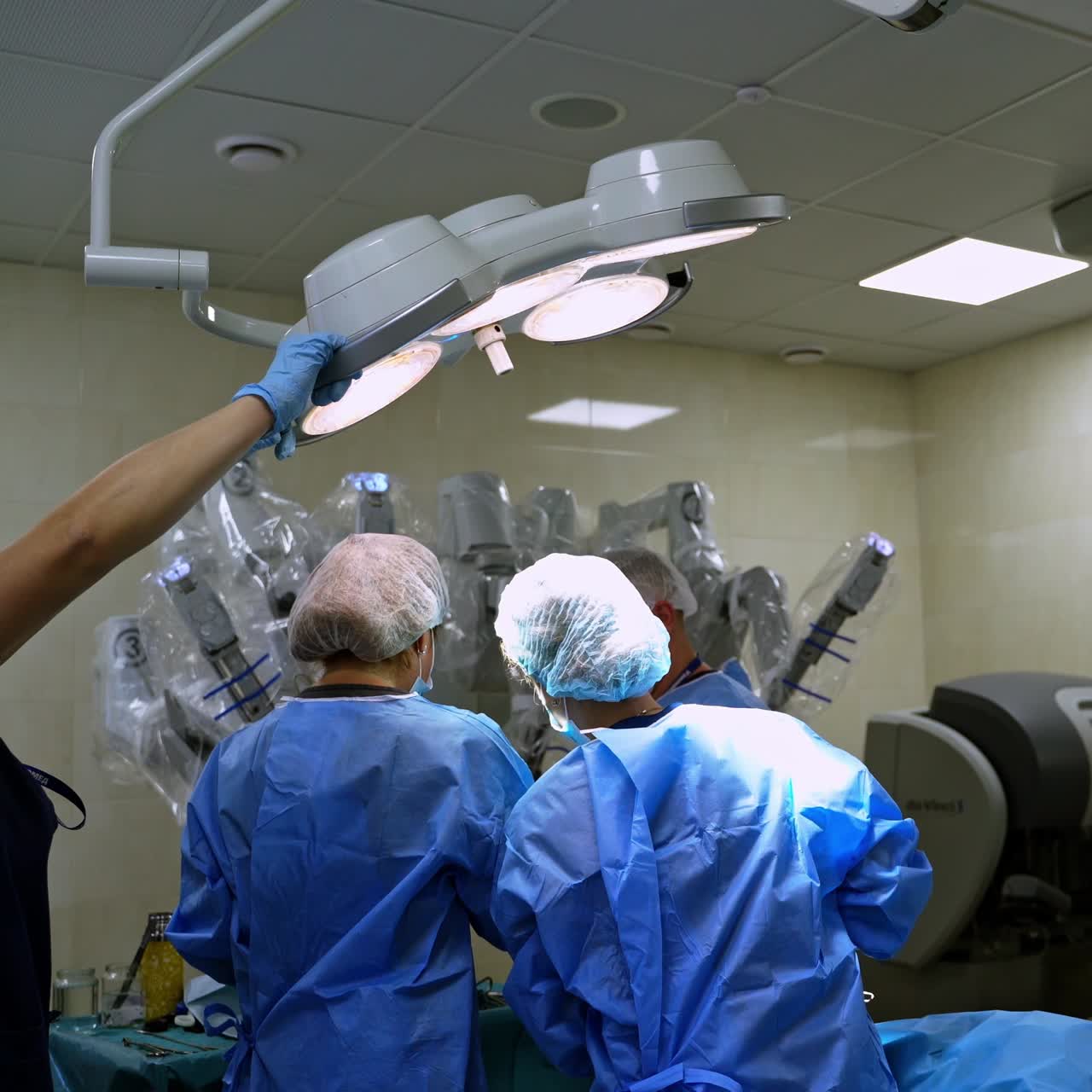 Medical team perform operation. Medical assistant puts the lamp over the doctors before the surgery in operating room.