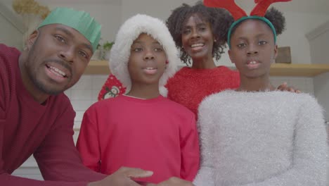 joyful family talking directly into webcam and waving goodbye during christmas video call