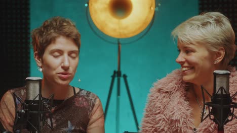 two young female bloggers giving interview in podcast recording studio