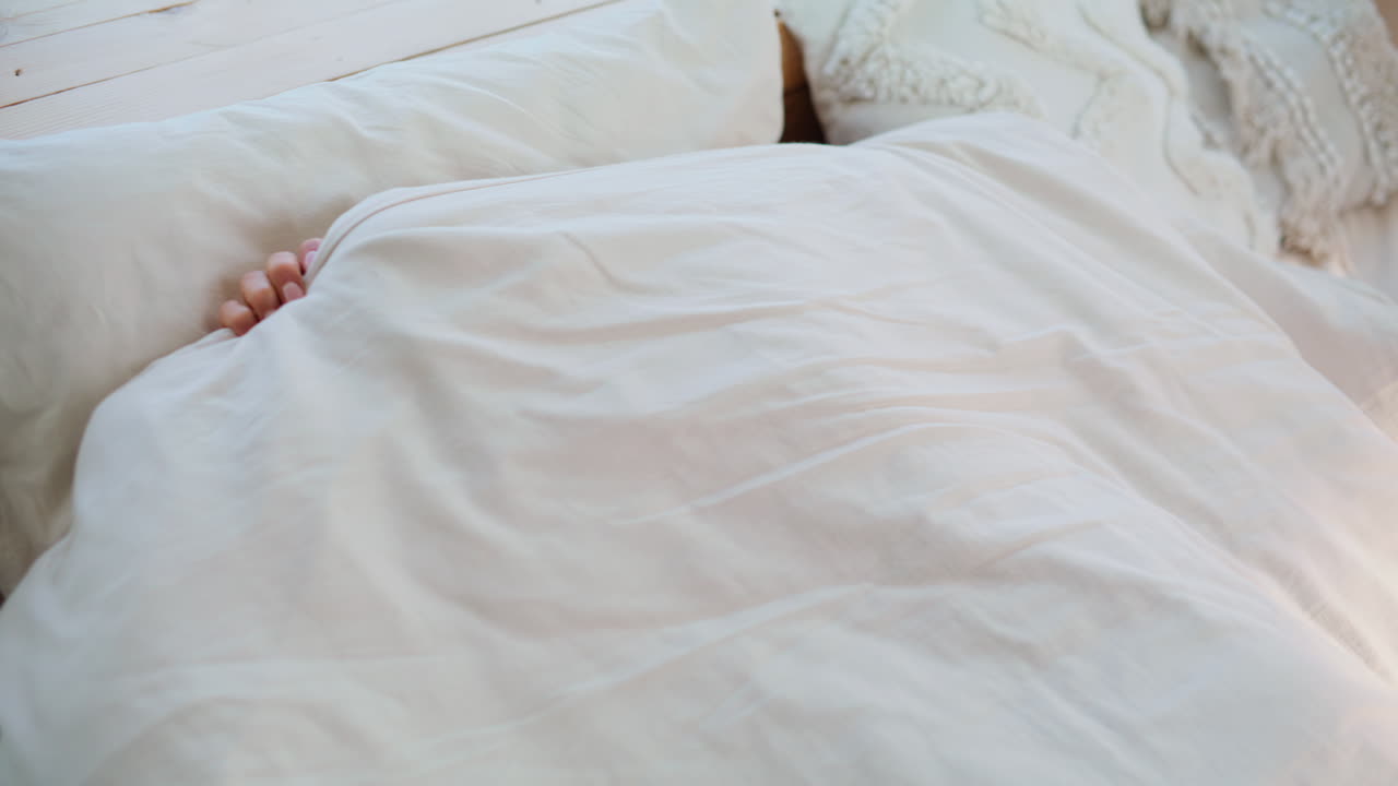 Primo piano di una donna stanca che guarda la sveglia dello smartphone mentre è sdraiata a letto. Brunetta sconvolta