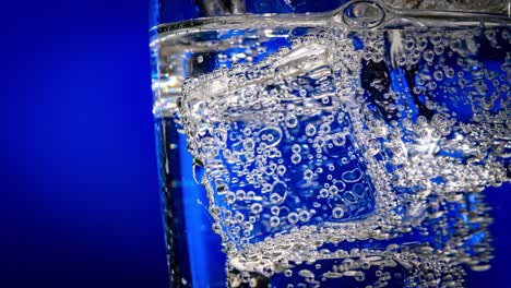 glass of water with ice on a dark blue background