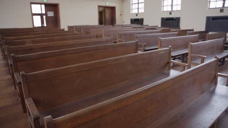 old wooden pews in empty hall, background pan shot