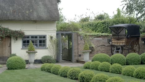 right pan shot of an old english cottage with a carriage