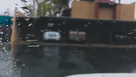 raindrops on driving car windshield, closeup