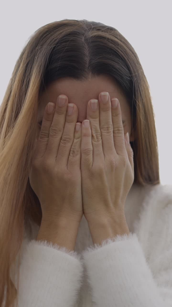 Donna nasconde il viso e poi rivela un sorriso felice