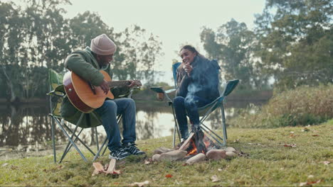 camping, fire and music with a guitar couple