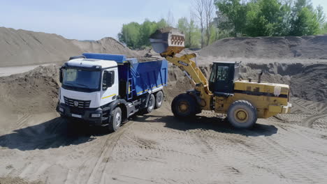 camión cargado con material de una cargadora de ruedas en un sitio de construcción