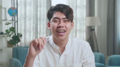 close up of asian man student waving hand and talking at home