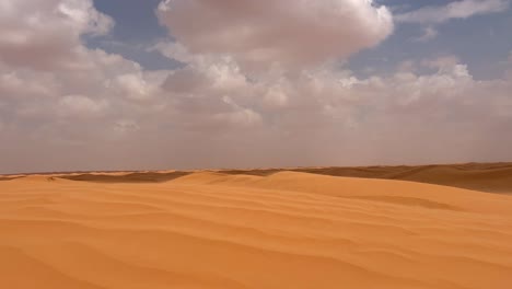las dunas del desierto cambian de color con el paso de las nubes por encima