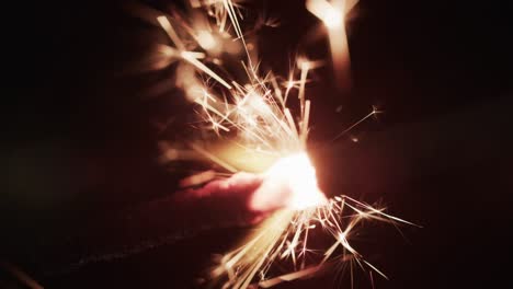 Video-of-close-up-of-sparkler-and-copy-space-on-black-background