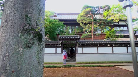 Two people talking quietly at the exit of a temple in Tokyo, Japan