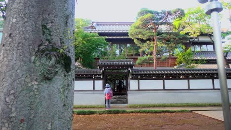 two people talking quietly at the exit of a temple in tokyo, japan