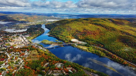 beautiful river separating the city from the mountain. aerial perspective on the scenery in autumn season. fluffy grey clouds cover the sky. top view.