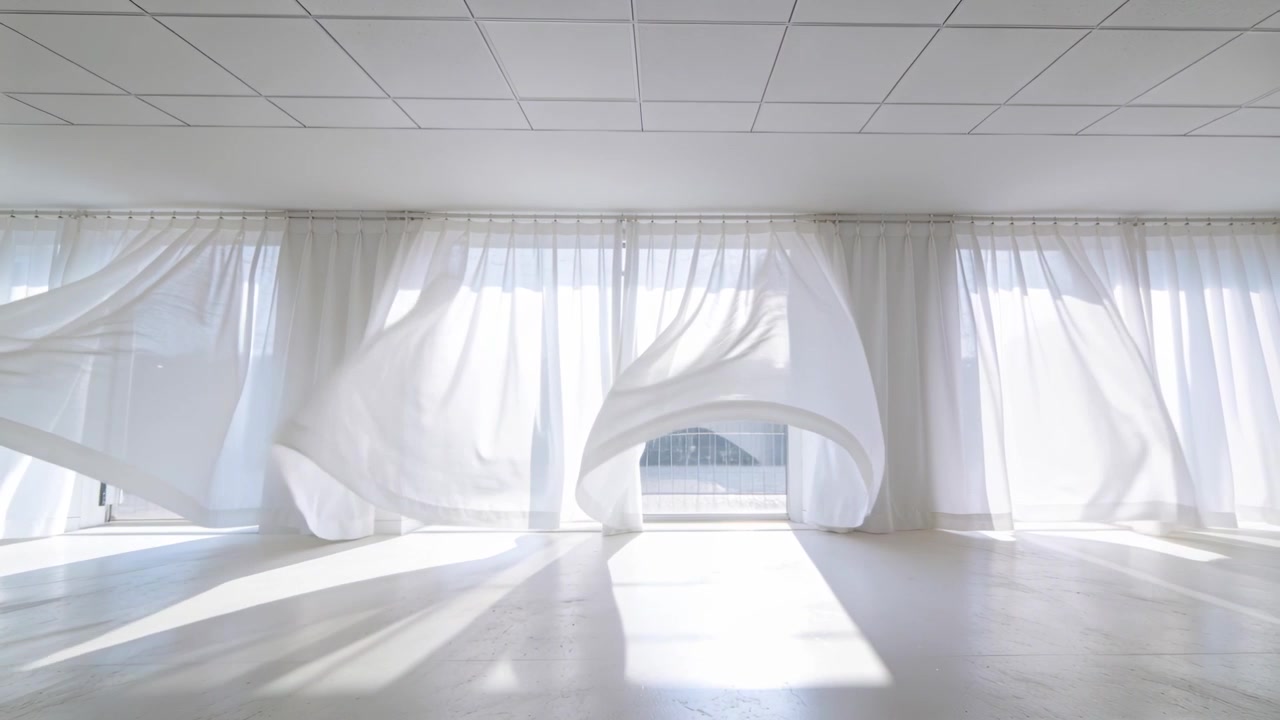 Billowing sheer drapes lifting rippling in sunlit studio, gust through glazing revealing shafts