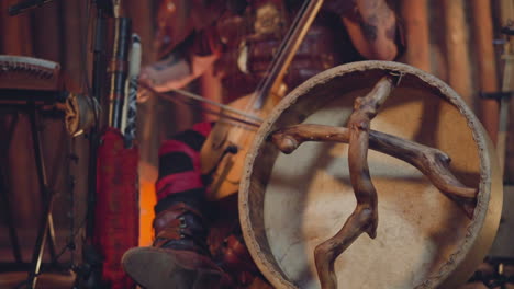 man plays igil on stage focus on shamanic tambourine