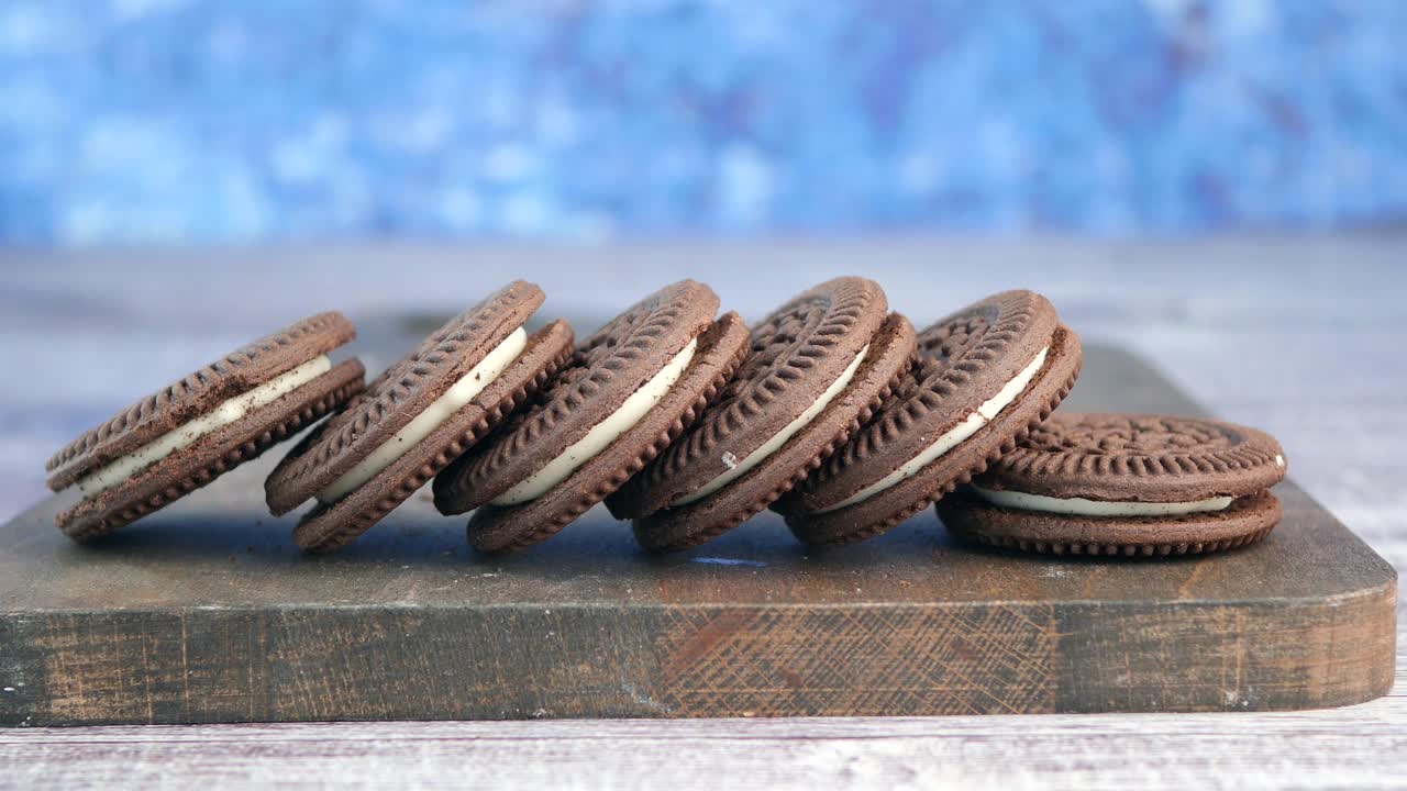 Chocolate sandwich cookies with cream filling on a wooden board