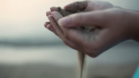 Sea-sand-running-through-a-womans-hands