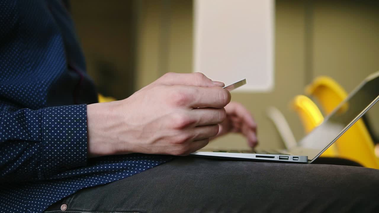 Male hands typing something on laptop keyboard.