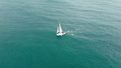 aerial shot of a drone flying around a sailing boat on the english ocean