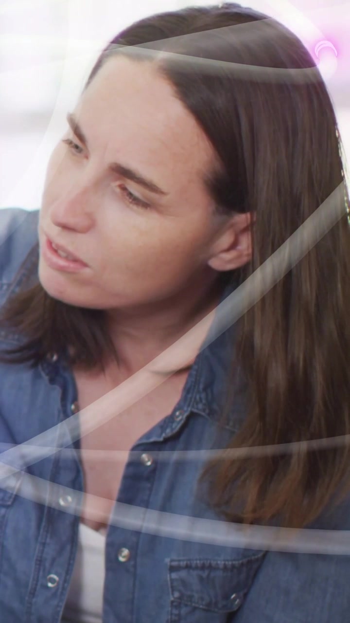 Video verticale: Donna che si gira verso un segnale fuori campo, rispondendo, con luci tecnologiche che scorrono sul busto.