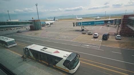 airport tarmac with airplanes and shuttle bus
