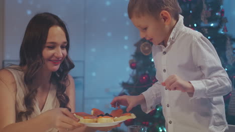 the boy asks for a cake in the holiday. a boy of 3-5 years laughs and demands a cake at the holiday table. shout congratulations and ask for food. high quality 4k footage