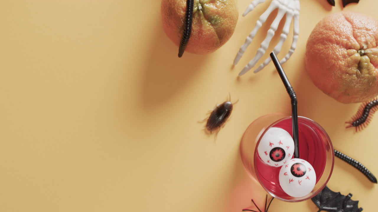 노란색 배경에 복사 공간과 함께 할로윈 음료와 장식의 비디오