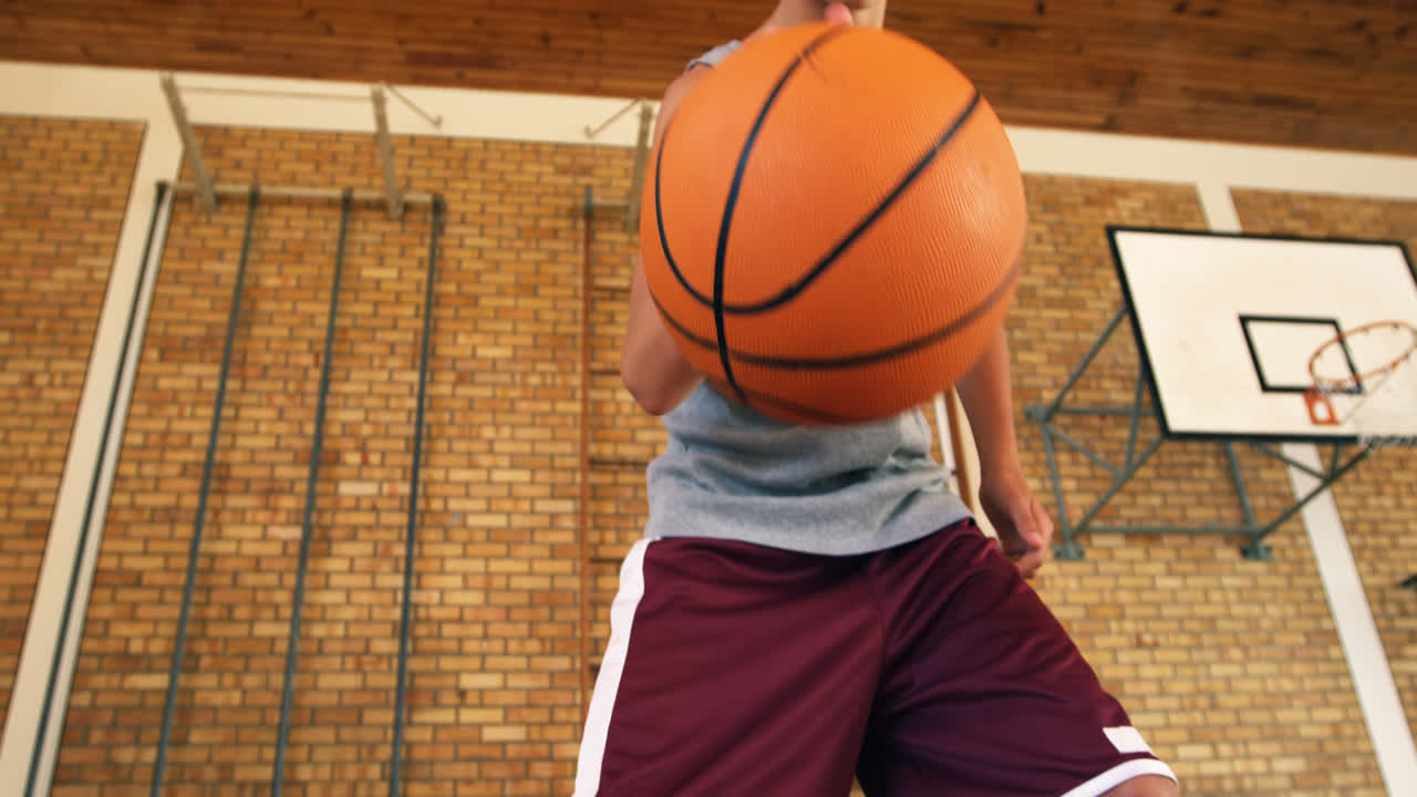 un chico de secundaria practicando el dribble.