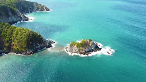 Secluded,-lush-green-islet-surrounded-by-the-turquoise-waters-of-Tayrona-National-Park,-Colombia