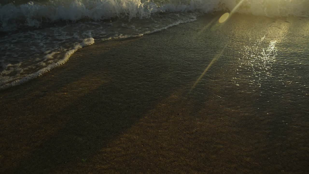 Onde su una Spiaggia Dorata al Tramonto