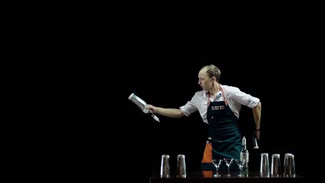 professional bartender in apron juggles bottles