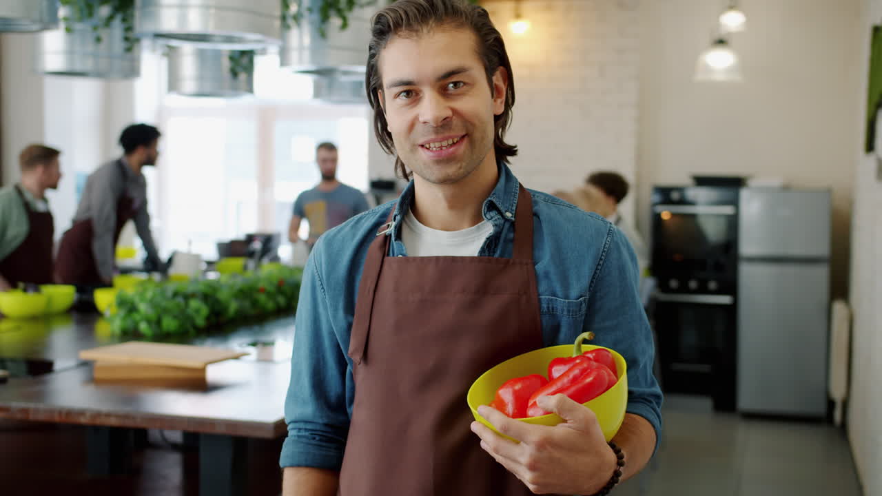Man Holding Peppers in a Community Kitchen
