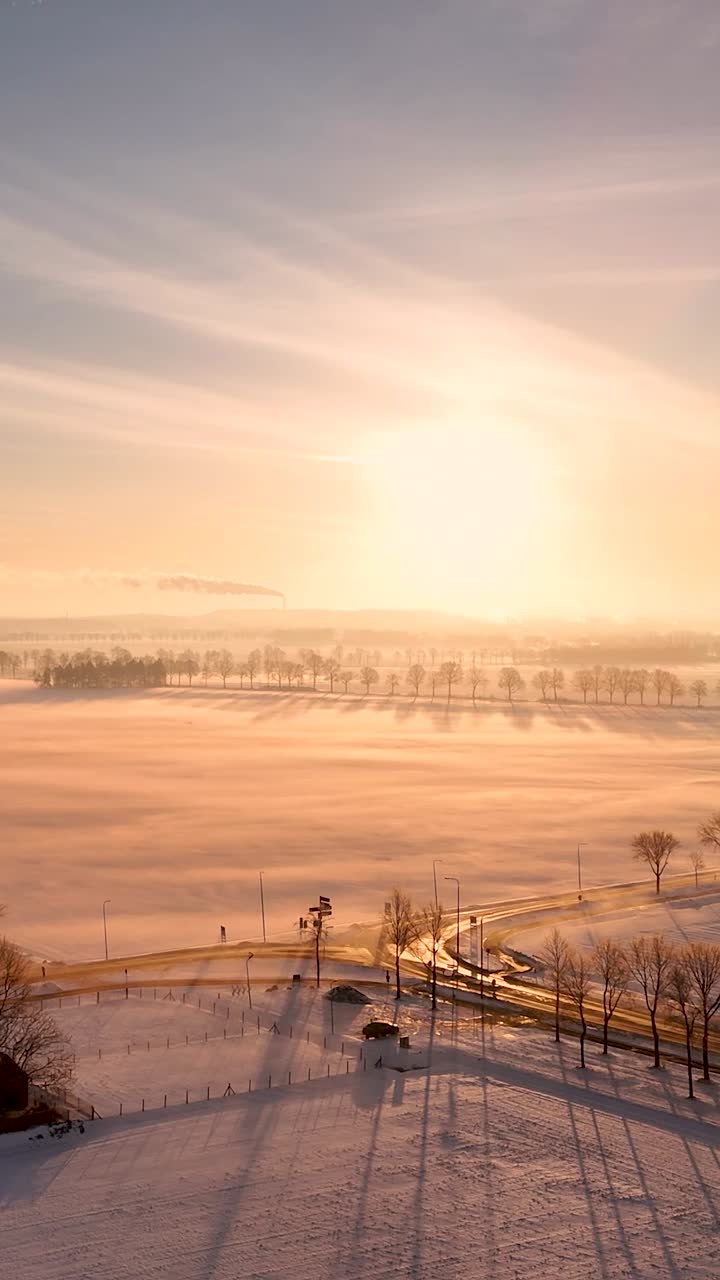 Vinterlandskap med snø og tåke ved solnedgang
