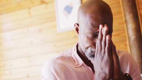 Senior-african-american-man-spending-time-in-log-cabin-and-praying,-slow-motion