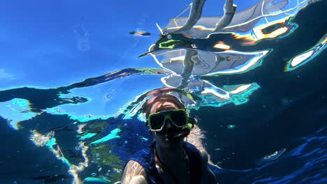 hand-handled gopro of caucasian snorkeling, thumbs up for the nice clear sea water of cebu, philippines