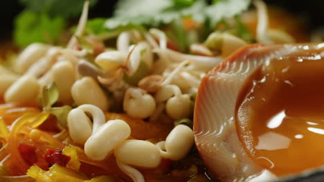 close-up of asian noodle soup with egg and vegetables