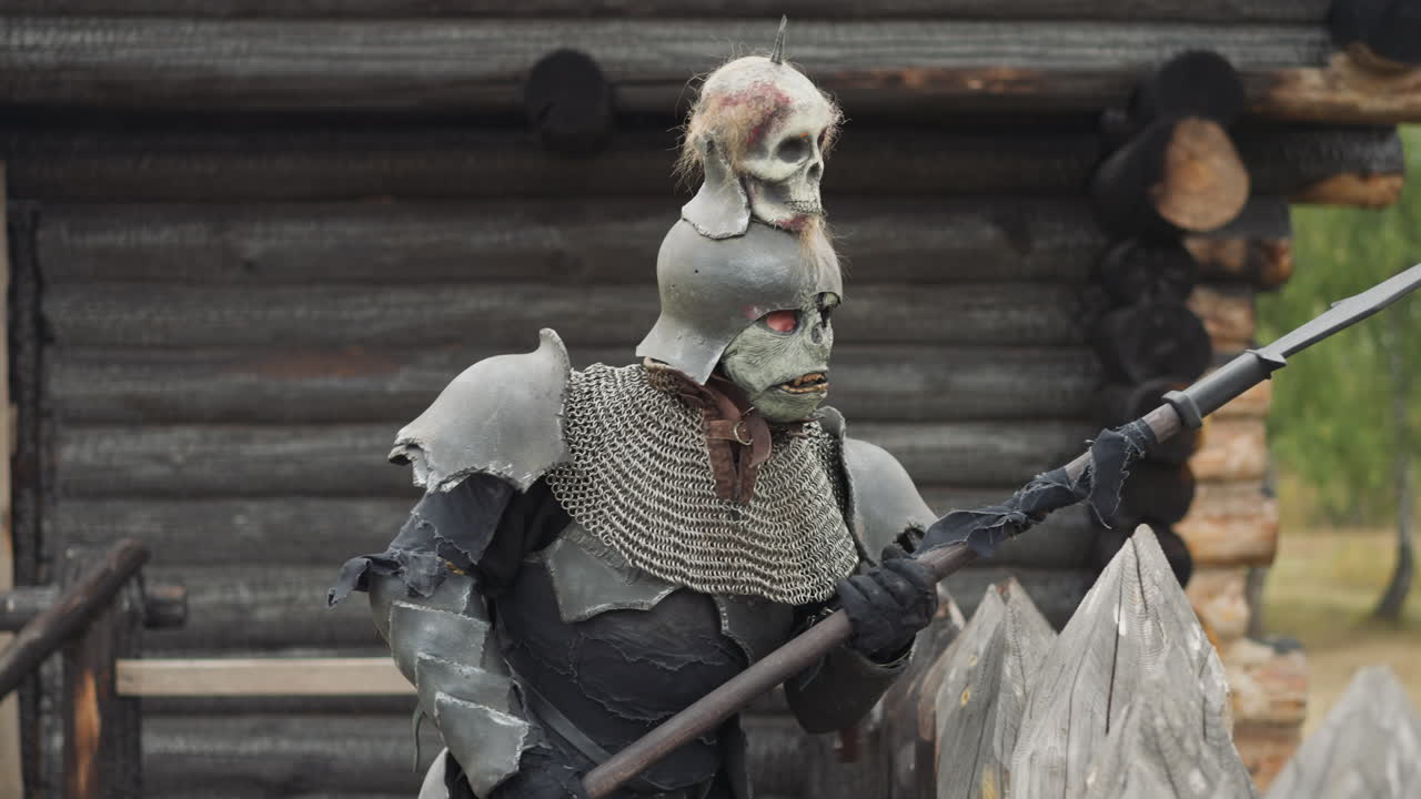 monstruo medieval en armadura de caballero camina a lo largo de la valla de madera