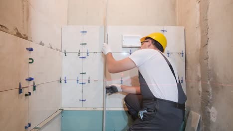 a professional builder installs ceramic tiles in a new building