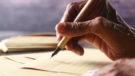 aged hands writing a letter with a fountain pen