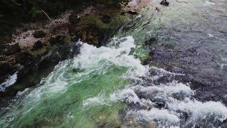 wild river with a small waterfall and crystal-clear water, drone flight