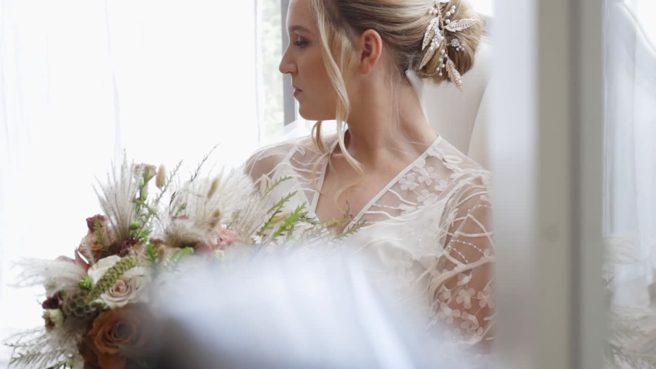 La novia sonríe en su bata a primera hora de la mañana
