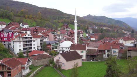 establishing shot of a small village in kosovo with mosque 2