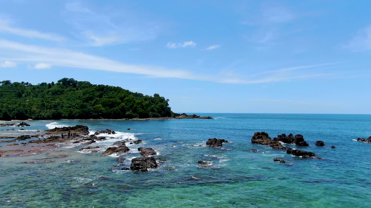 인도네시아 웨디옴보 해변의 바위에 파도가 부서지고 공중 전망