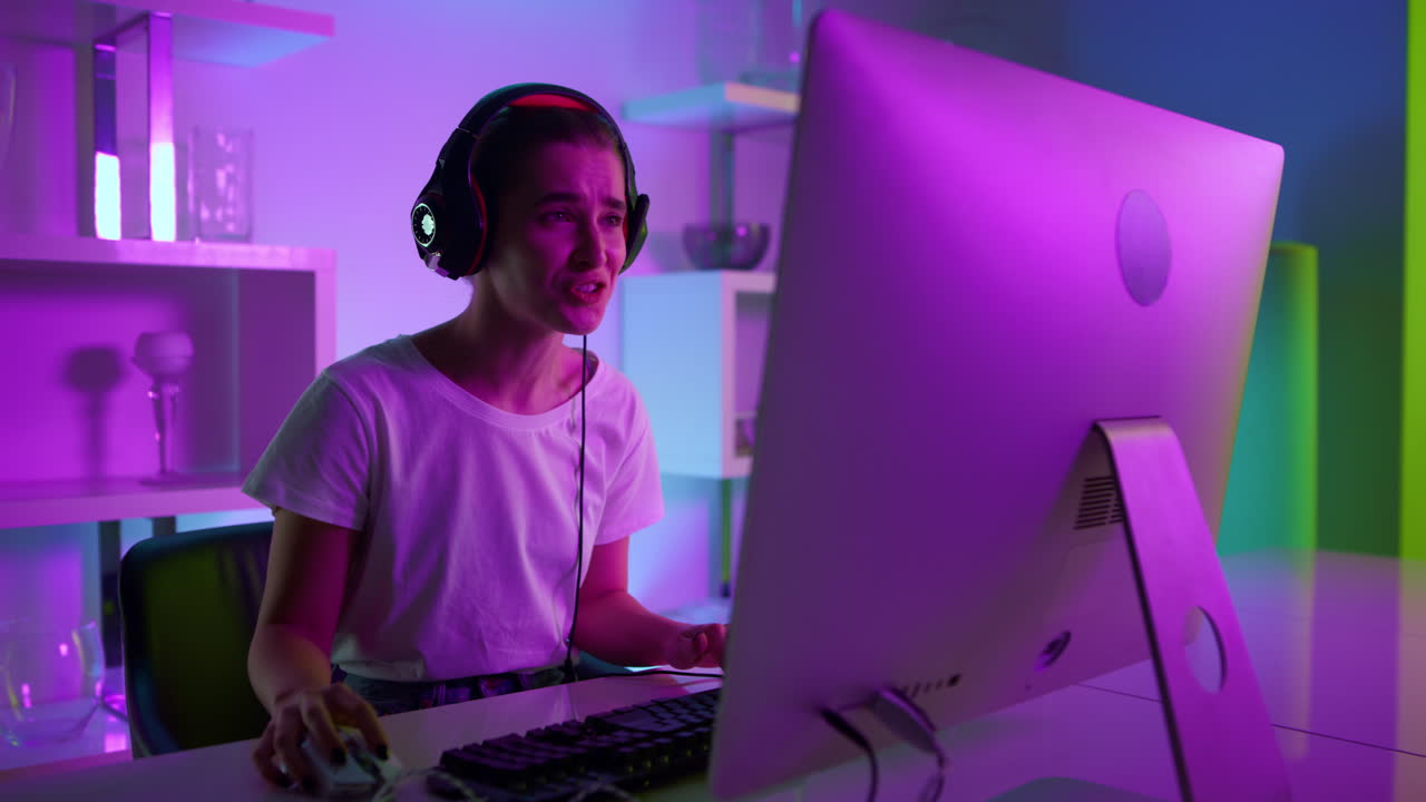 Streamer cyber che parla online con la sua squadra in primo piano. Giocatore gioioso al neon con le cuffie