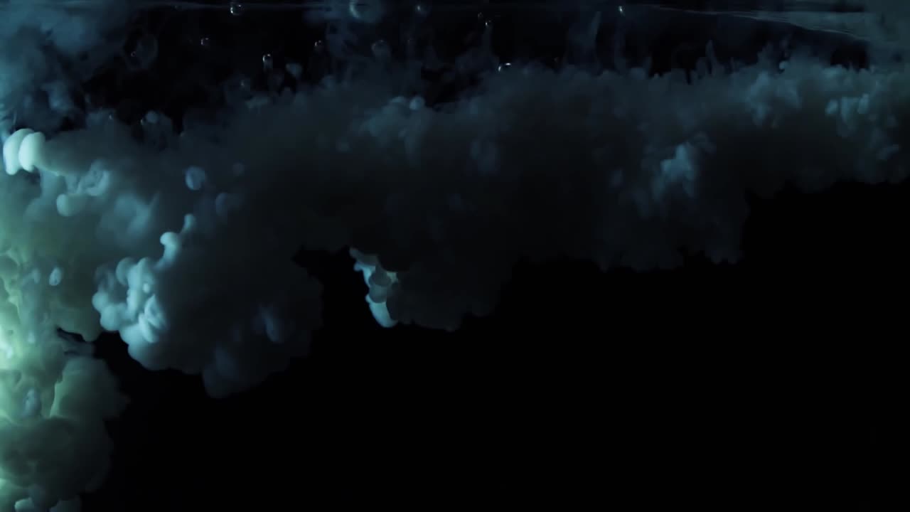 белая краска падает сверху, смешиваясь с водой.